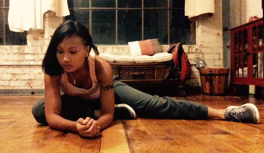 Image Description: A photo of Grace, sitting on the floor, stretching to her right. 